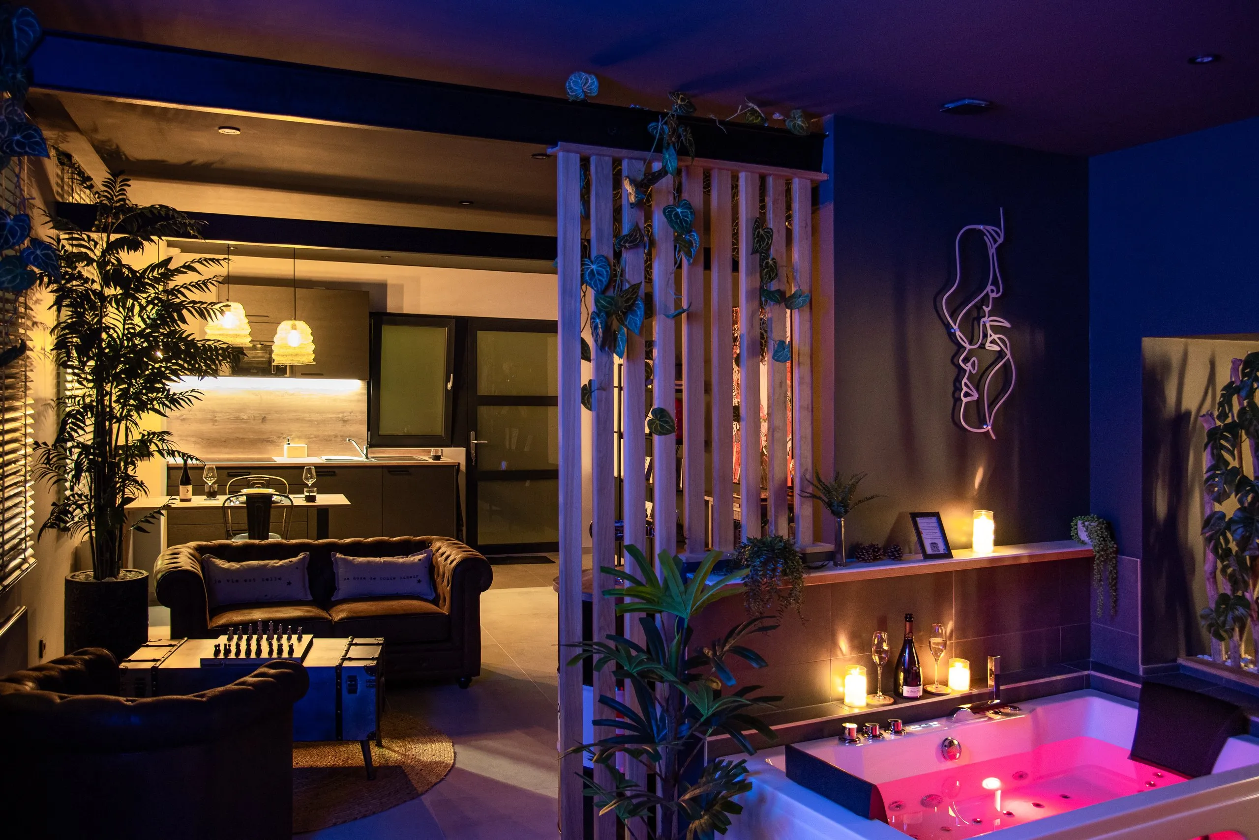 Le salon du loft et la baignoire balnéo éclairée en rose